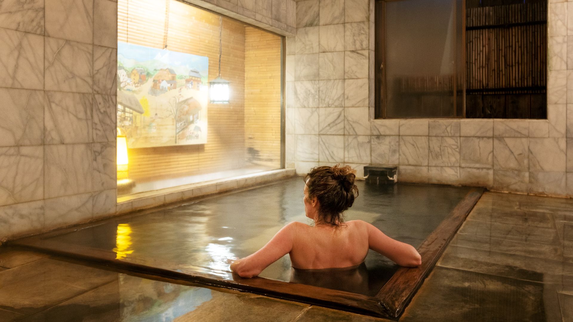 A woman experiencing Japan's onsen bathing culture. 