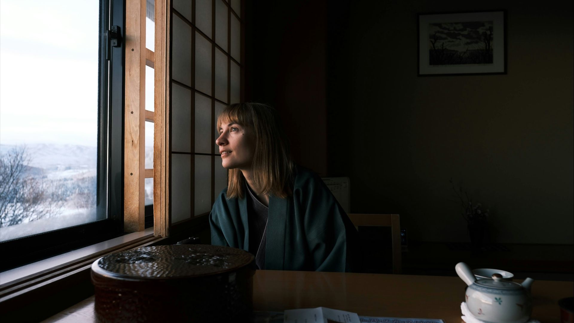 A solo traveller looking out a hotel window in Japan.
