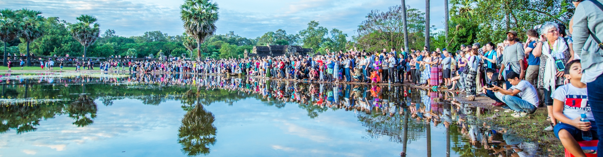 A large crowd of people crowded around a lake in Cambodia