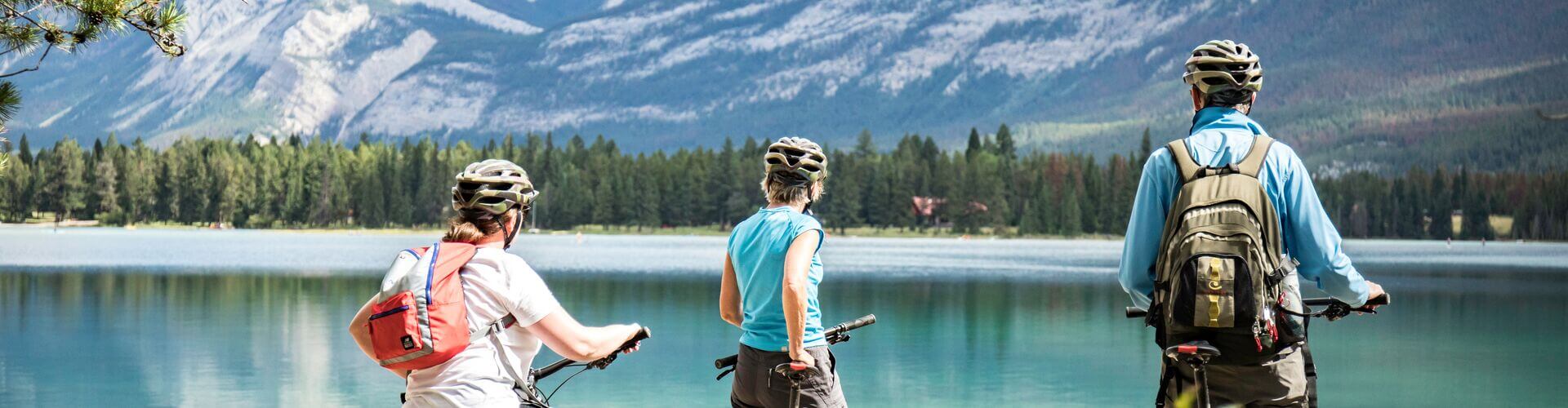 Cyclists looking out over Edith Lake at Jasper National Park