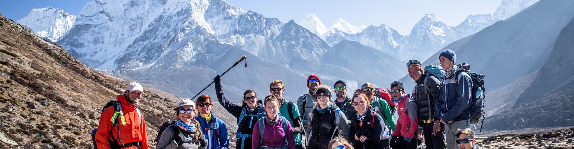 A group of Intrepid hikers posing for a photo with Mt Everest in the background