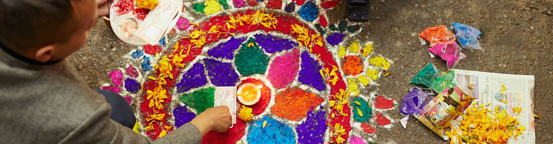 Locals creating a colorful mandala on the street in Kathmandu, Nepal