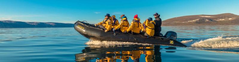 Passengers in a Zodiac boat in the waters of Greenland