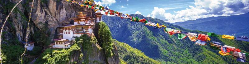 HEPIC - View of the Tiger Monastery and colourful flags on a hill in Bhutan