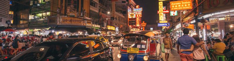 Street view of the hustle and bustle of Bangkok lit up at night