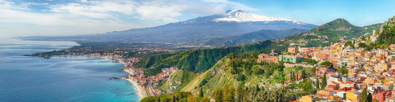 View of the town Taormini on the Sicilian coast with Mt. Etna in the background, Italy