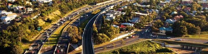 Cars travelling along the Brisbane to Gold Coast highway among houses and greenery