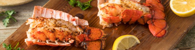 Cooked lobster tails on a wooden board 