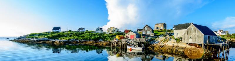 Colourful fishing houses on the edge of Peggy's Cove under blue skies in Nova Scotia