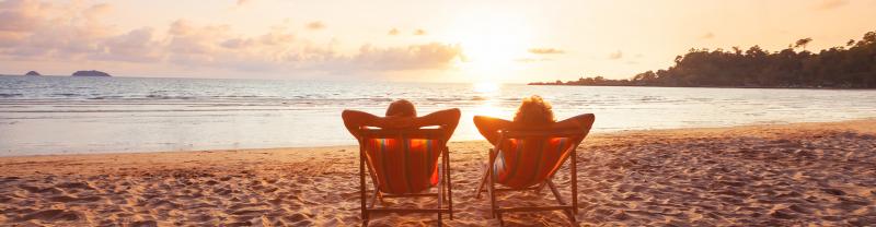 Two travellers watching the sunset on the beach in the Cook Islands