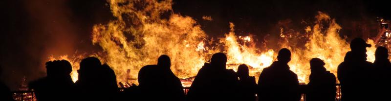 People standing around a bonfire during the Beurgbrennen festival in Luxembourg.