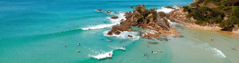 A bunch of surfers in the clear, blue waters off Byron Bay, New South Wales 