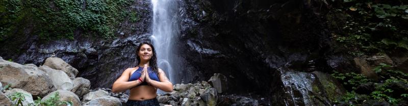 Traveller doing yoga in a waterfall