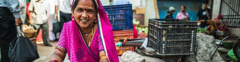 An Indian woman at a market wearing a pink sari