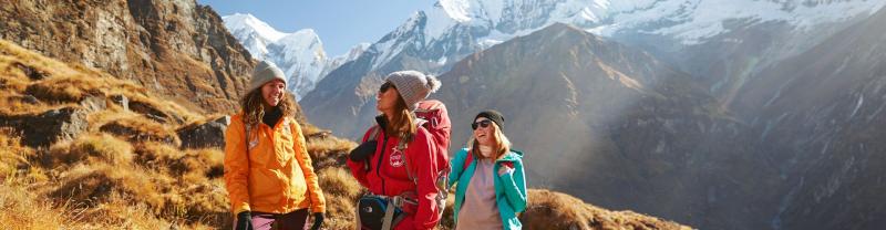 Three women laughing on a hike to Annapurna Basecamp, Nepal
