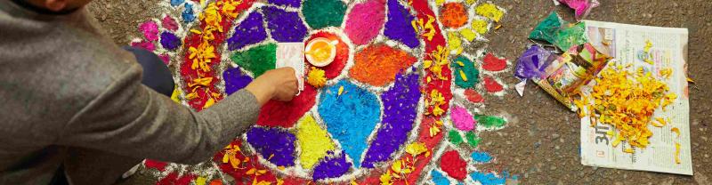 A local man creates a mandala out of colored sand and flower petals in Kathmandu