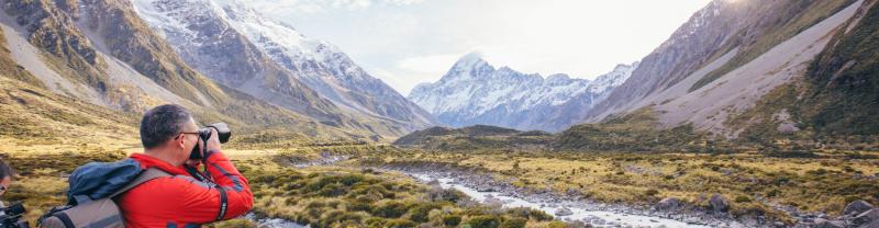 A hiker taking a photo of Mount Hooker in New Zealand