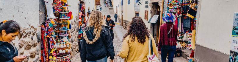 Two travelers walking down a street in Cusco, Peru