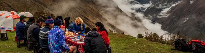 A group of hikers enjoying a basic meal together along the Inca Trail in Peru 