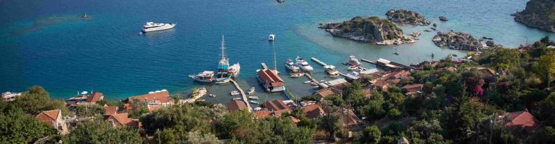 An aerial view over the gulet boats in the bright blue harbor of Kas in Turkey