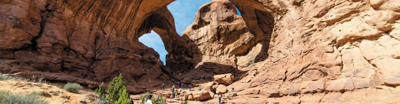 A group of hikers walking through Arches National Park, Utah