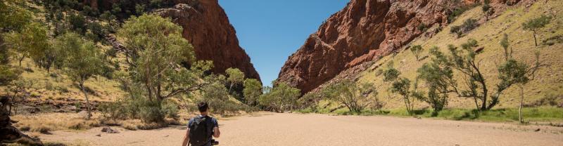 A traveller hiking through the West Macdonnell Ranges in Australia