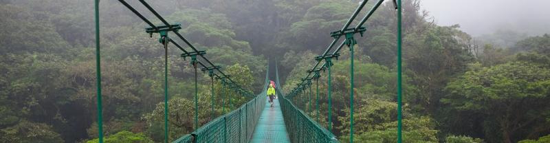 Travellers walking along a suspension bridge among the clouds in Monteverde, Costa Rica
