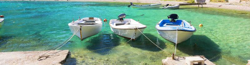 Three small boats moored in Croatia's turquoise waters