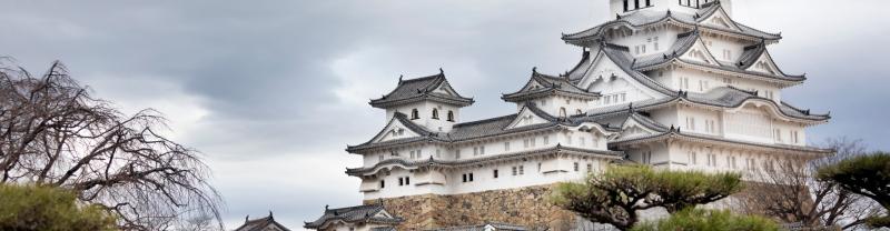 The beautiful architecture of Himeji Castle set against a cloudy sky in Japan.