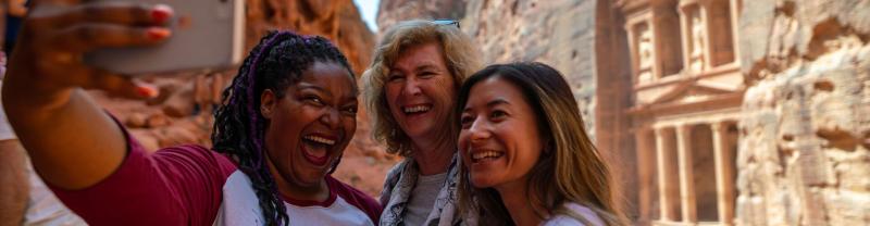 Three women taking a selfie in front of Petra in Jordan