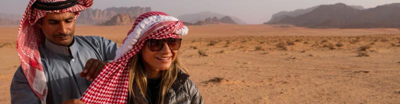 A traveller being dressed in a head wrap in Wadi Rum