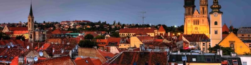 A view of the rooftops of Zagreb with the glowing cathedral in the background