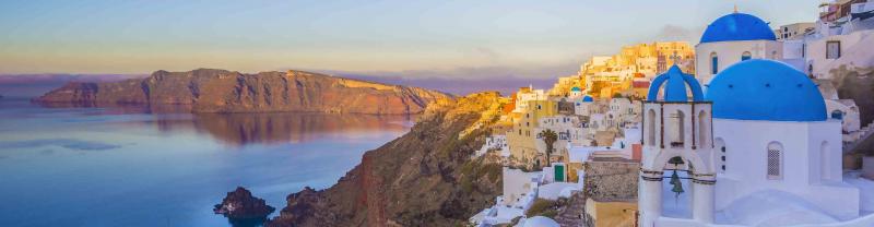The sun sets over the iconic blue rooftops of Oia on Santorini