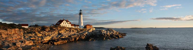 A lighthouse off the coast of Maine shines during golden hour