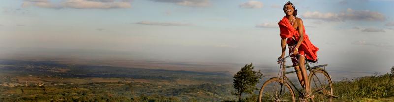 Masai warrior riding bicycle on Ngong Hills in Kenya