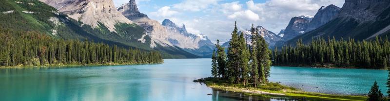 The crystal clear surface of Maligne Lake with snow-capped mountains in the background
