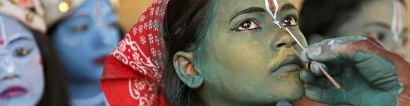 Face of youth in India being painted in preparation of a Hindul festival