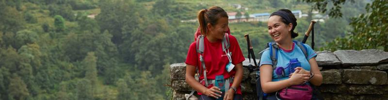 A female Intrepid leader and female traveller rest during a trek in Nepal