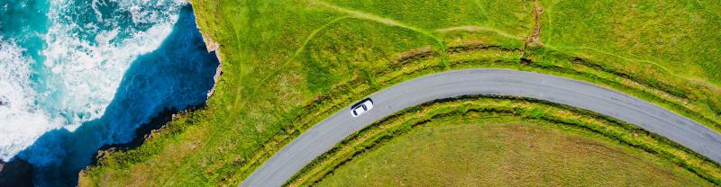 An aerial image of a car driving along the Kilkee Cliffs in Ireland