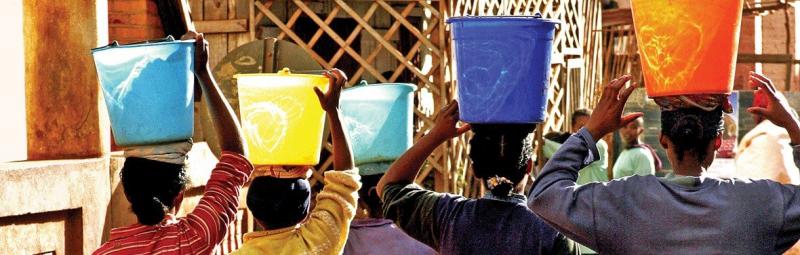 People carrying buckets on their head in Madagascar
