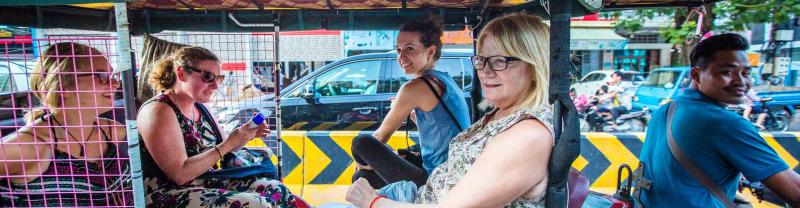 Group of travelers take rickshaw in Cambodia