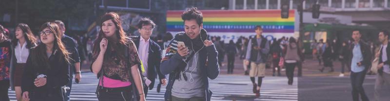 Crowded streets of tokyo with rainbow banner 