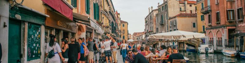 A busy street by a canal in Venice
