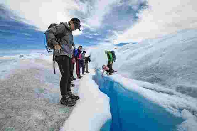 A group of travelers inspecting the Perito Moreno Glacier in Argentina 