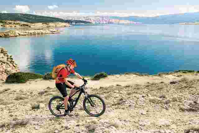 A cyclist riding off-road along the coast in Croatia