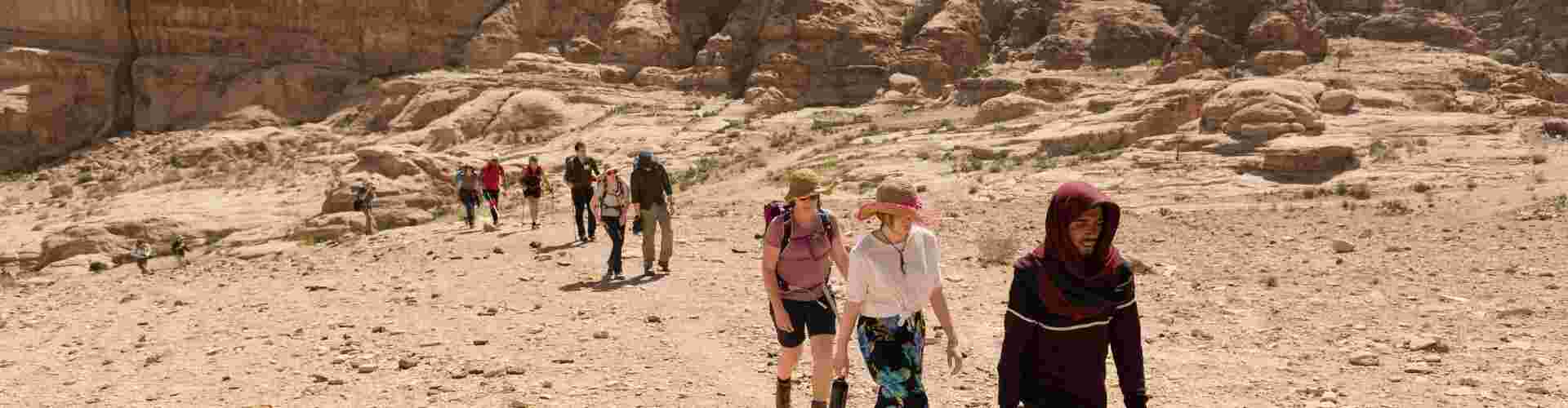 A group of travellers walking through the desert in Petra, Jordan 