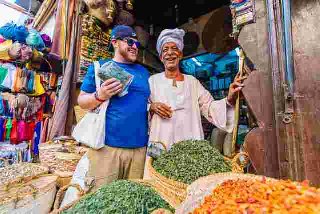A traveller buying herbs from a local trader at a market in Aswan, Egypt