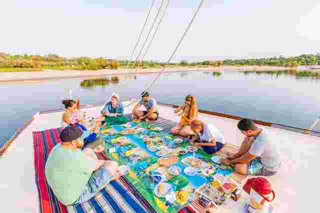Seven travelers eating lunch on a felucca on the Nile in Egypt