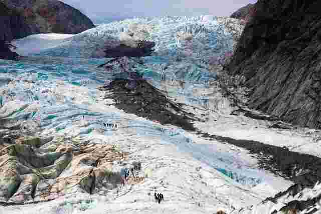 A group of hikers standing at the bottom of Franz Josef Glacier