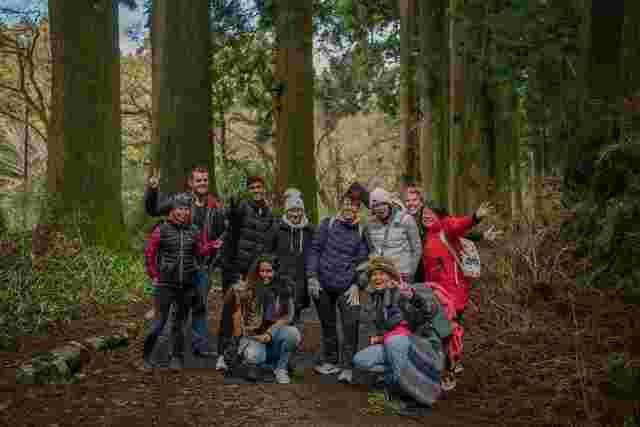 A group of travelers posing for a photo in a forest in Japan 